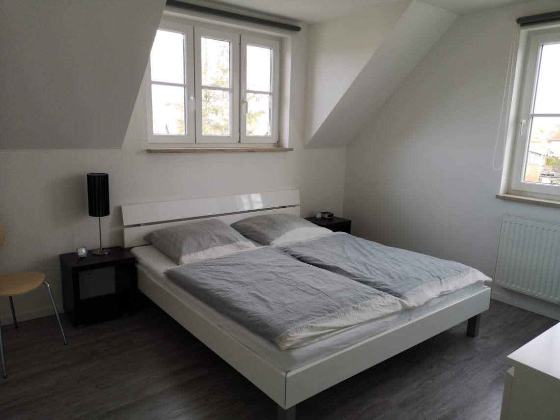 Schlafzimmer mit Doppelbett und Kommode