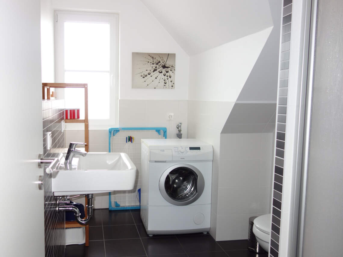 Bad mit Waschmaschine, Waschbecken und Fenster