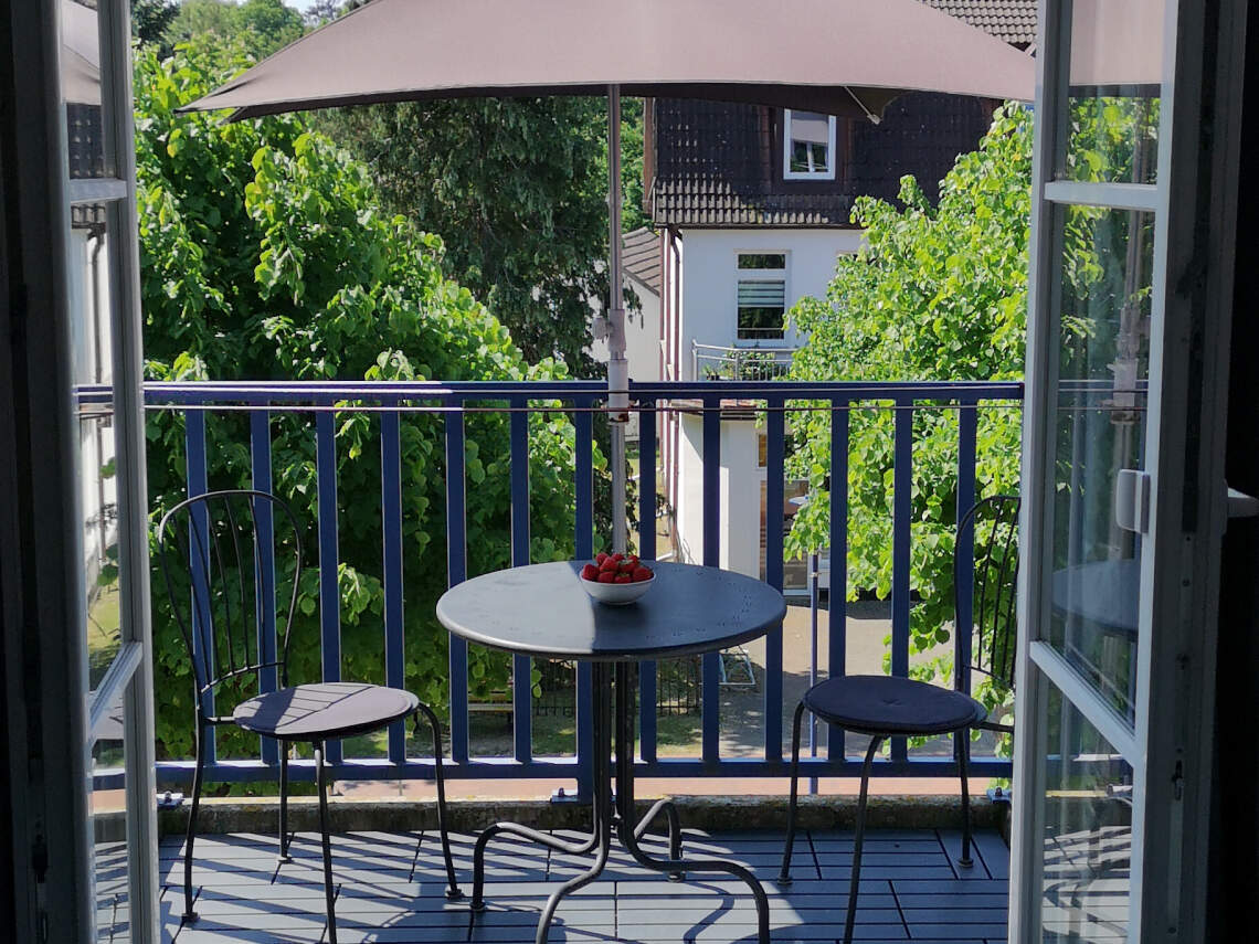 Balkon zur Südseite mit Sonnenschirm, Tisch und Stühlen