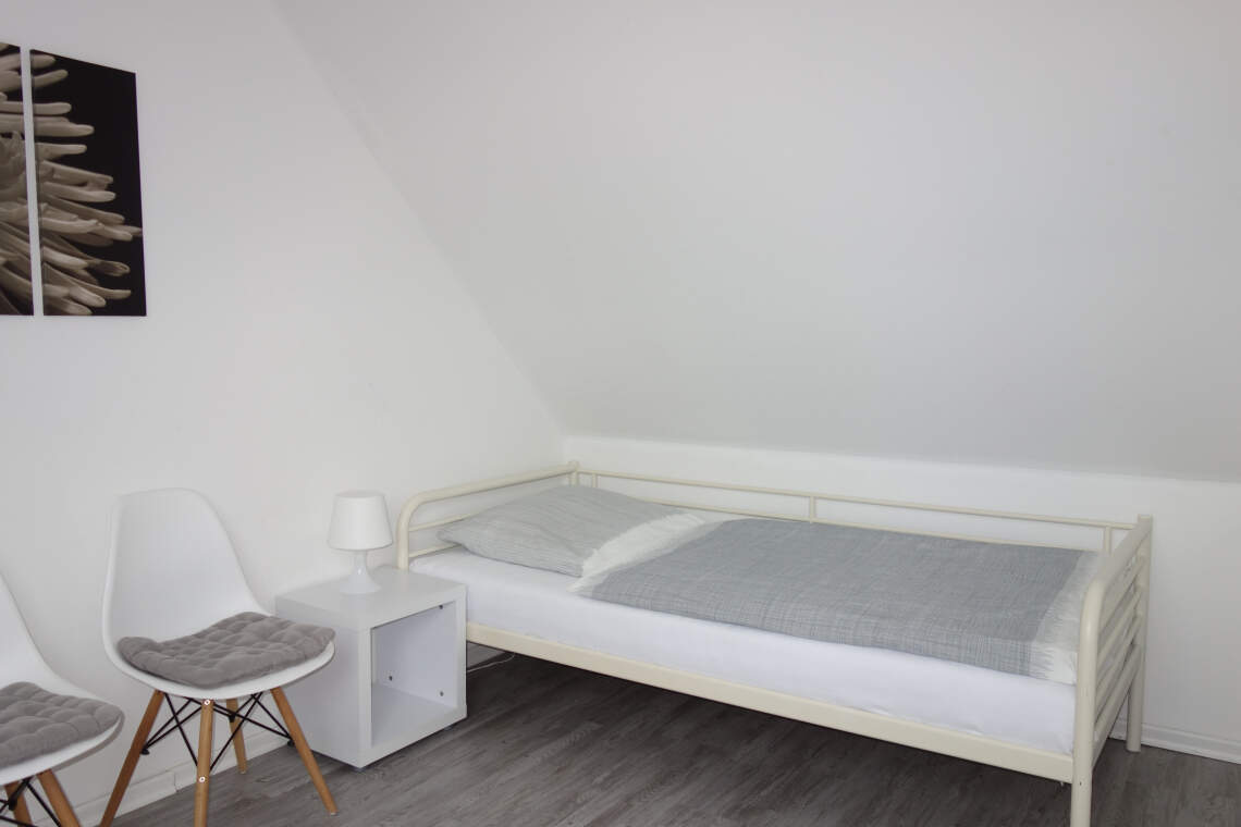 Oberes Schlafzimmer mit Einzelbett und Nachttisch